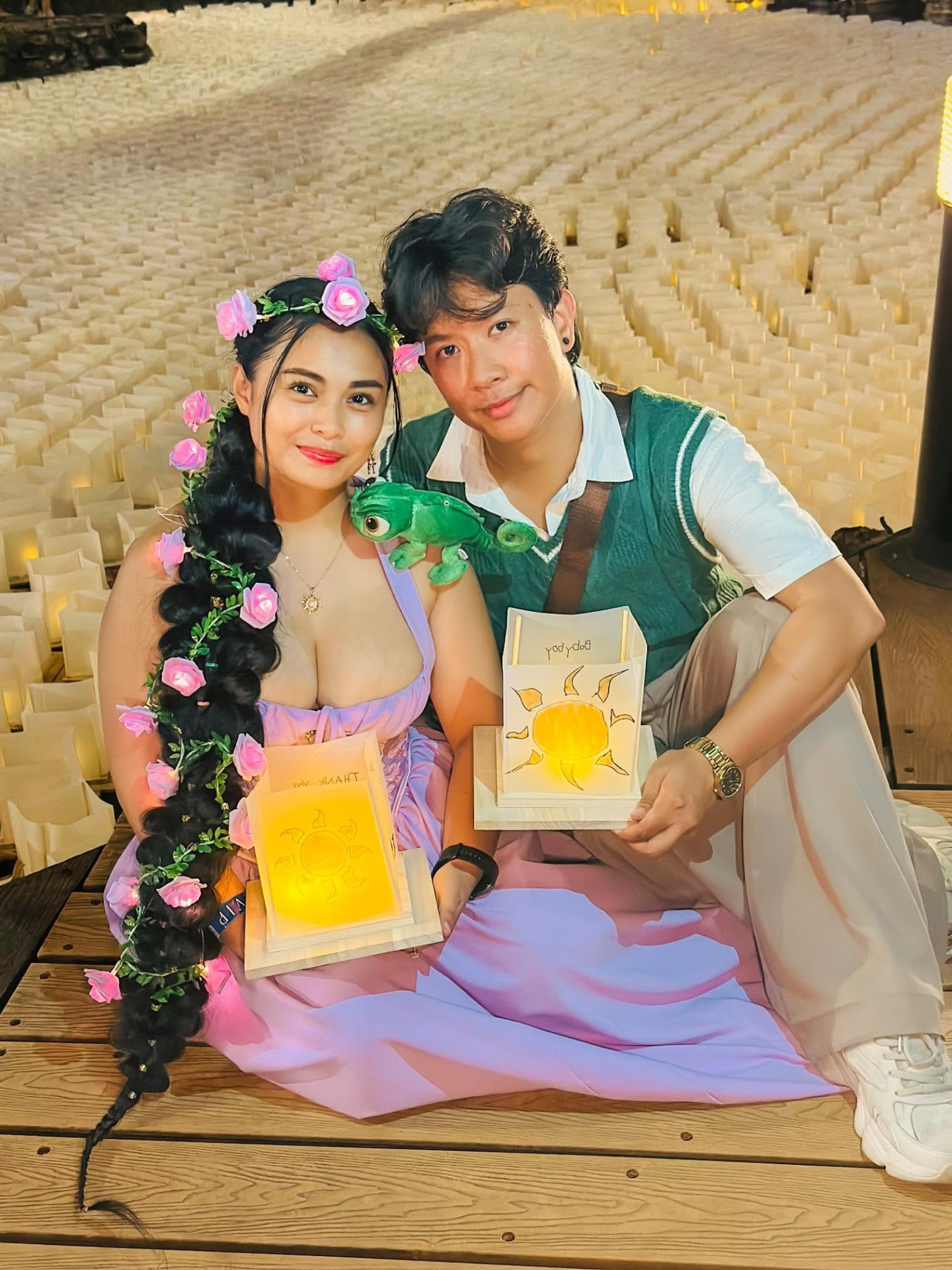Couple in costume holding illuminated water lanterns