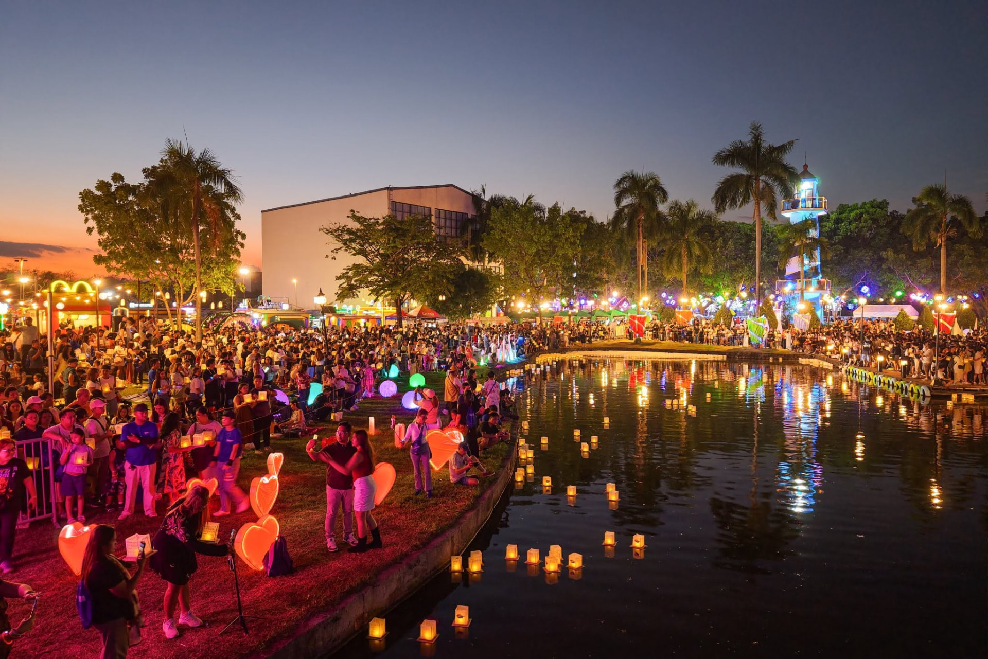 Crowds lining the water as lanterns drift across the lagoon