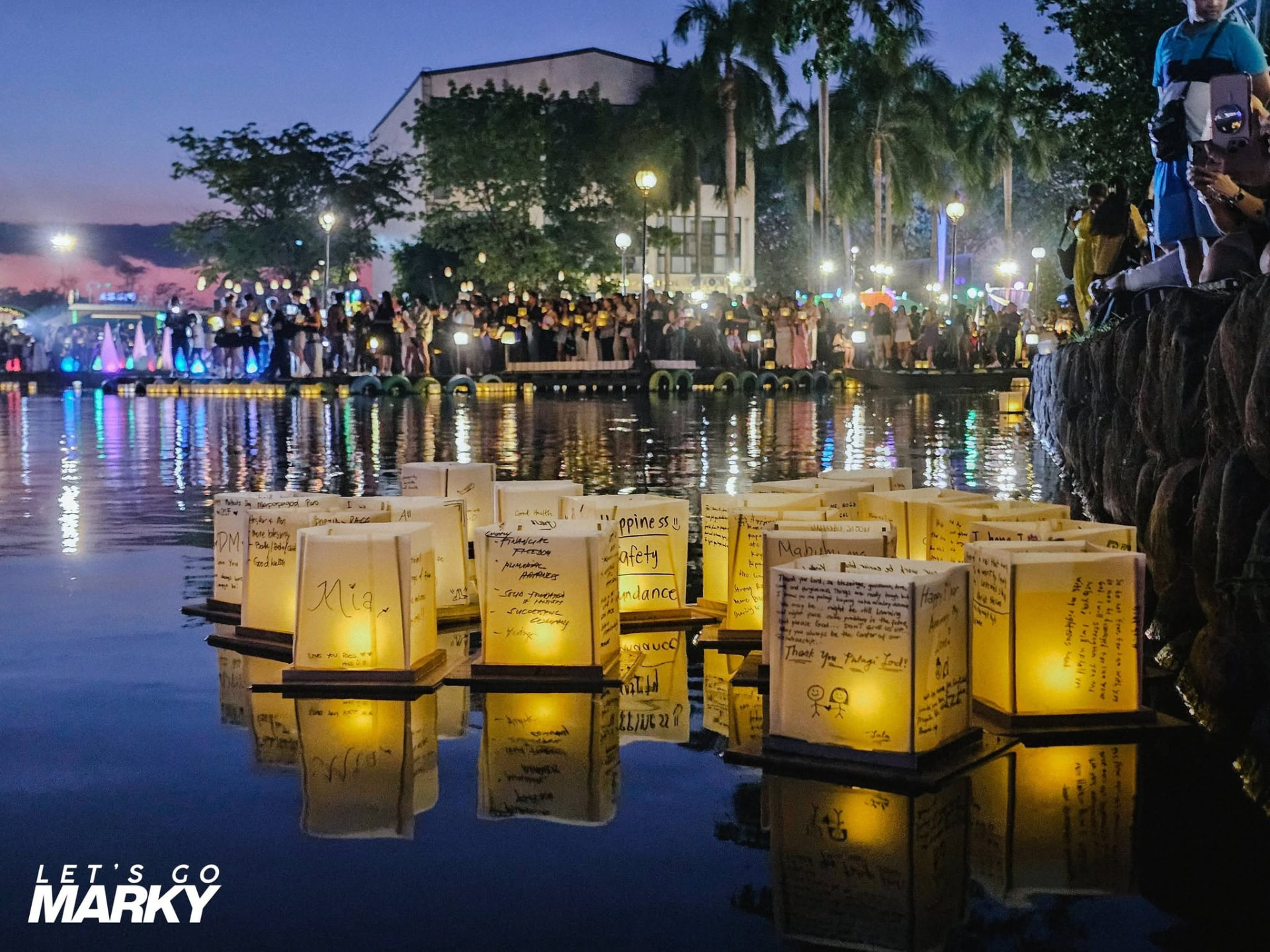 Handwritten water lanterns glowing on the water at dusk