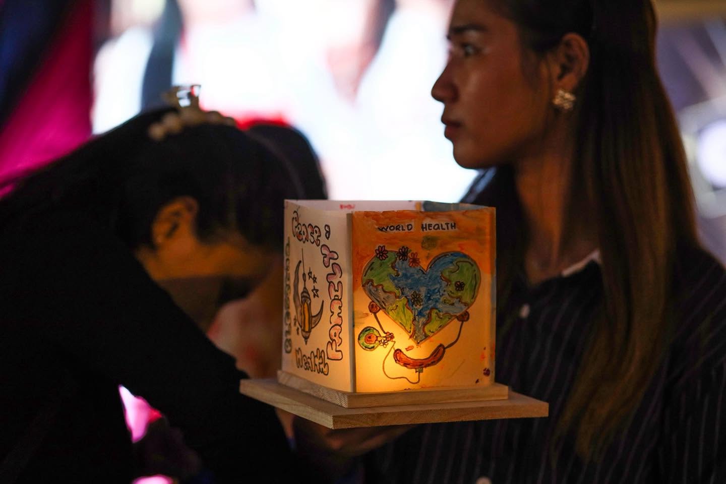Close-up of a hand-painted water lantern glowing warmly