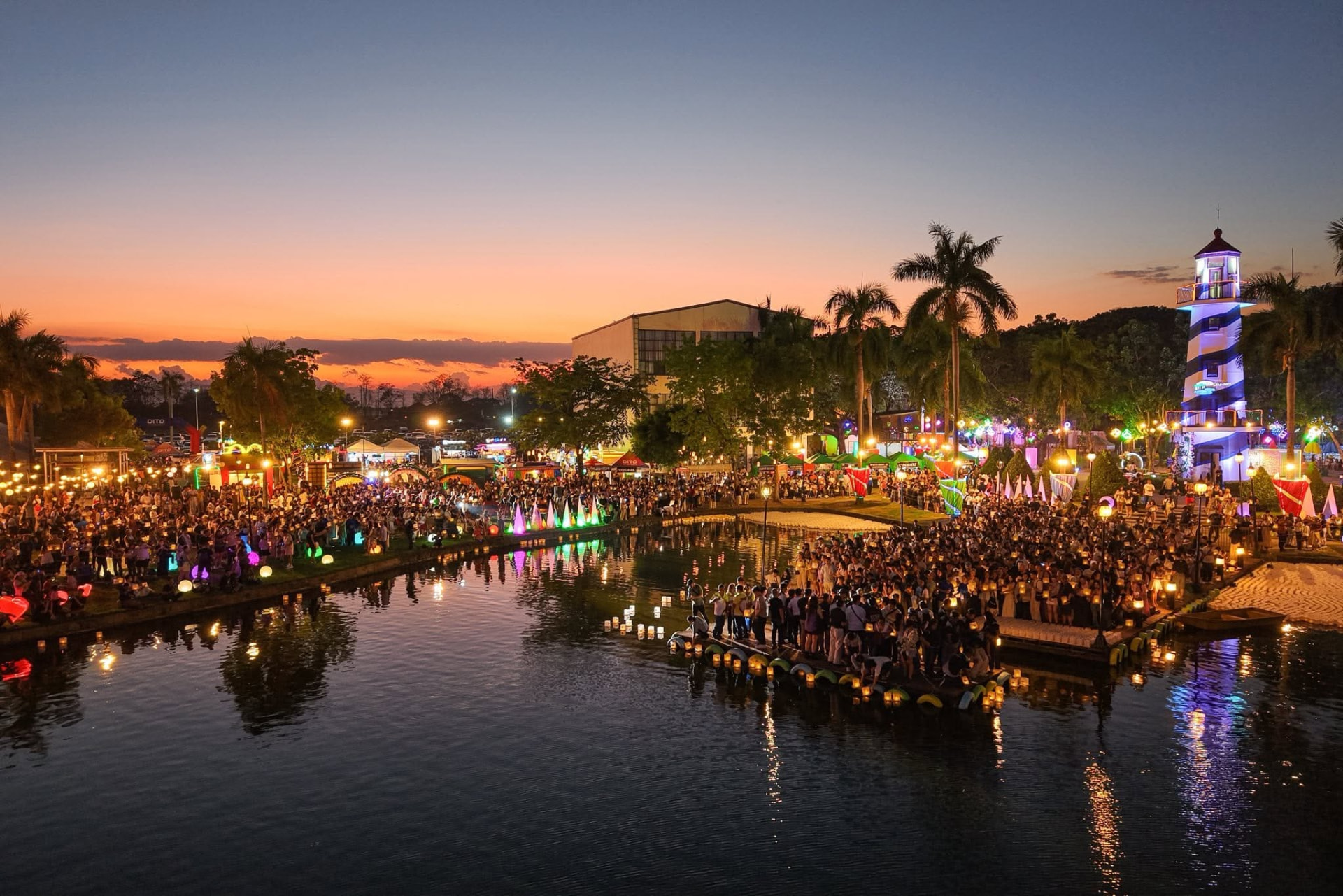 Thousands of guests releasing water lanterns at sunset along the boardwalk